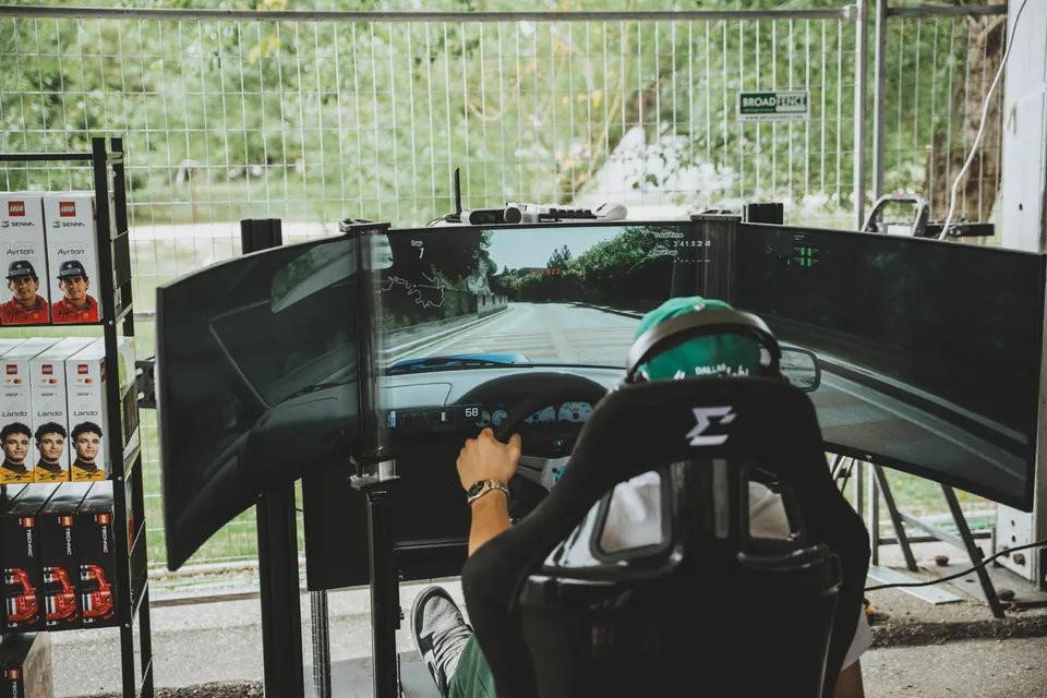 Person driving a triple-screen racing simulator